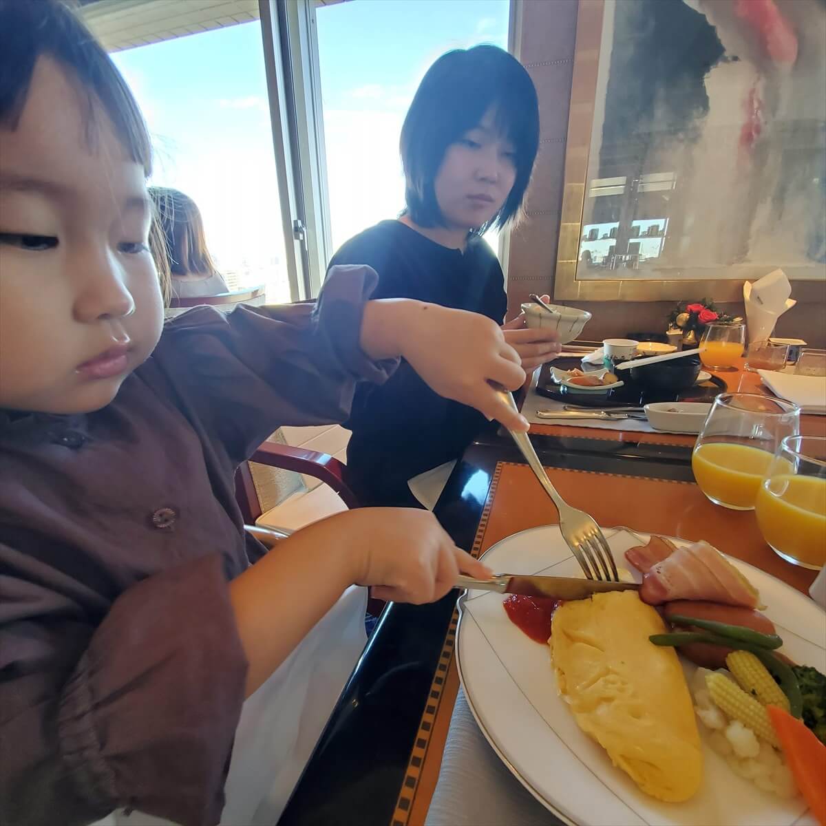 ウェスティンホテル東京のクラブラウンジ「ウェスティンクラブ」の朝食のセットメニューの洋食エッグプレートのオムレツを食べる娘